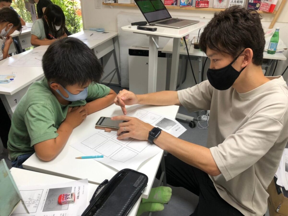 体験授業のイメージ写真。プリントとスマートフォンを使って小学生に個別で教える講師