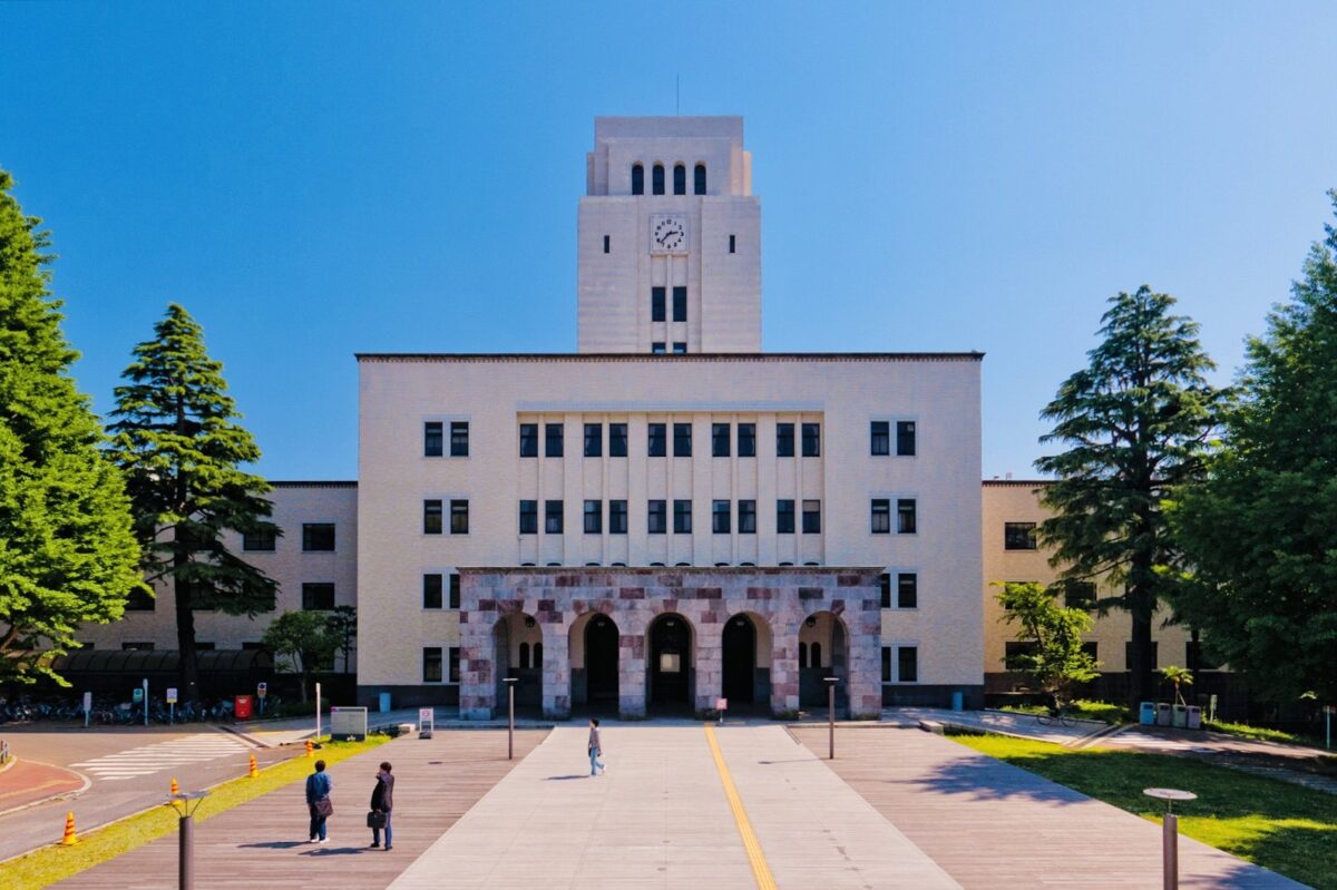 時計塔のある白い建物へ、まっすぐな広い道が続いている。道の両側に高い木が立っている