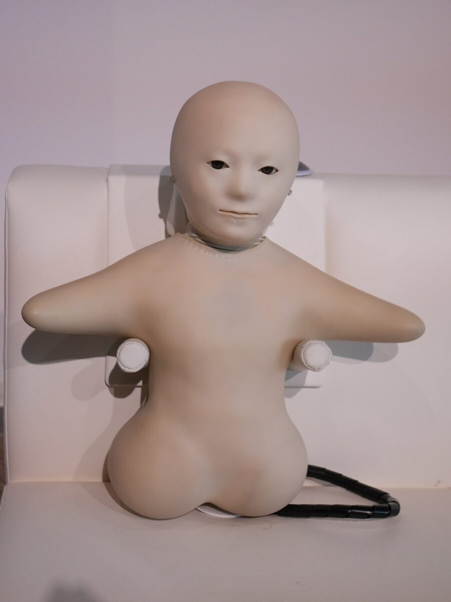 髪のない白い顔と、短い腕の白い胴体だけのロボット「テレノイド」