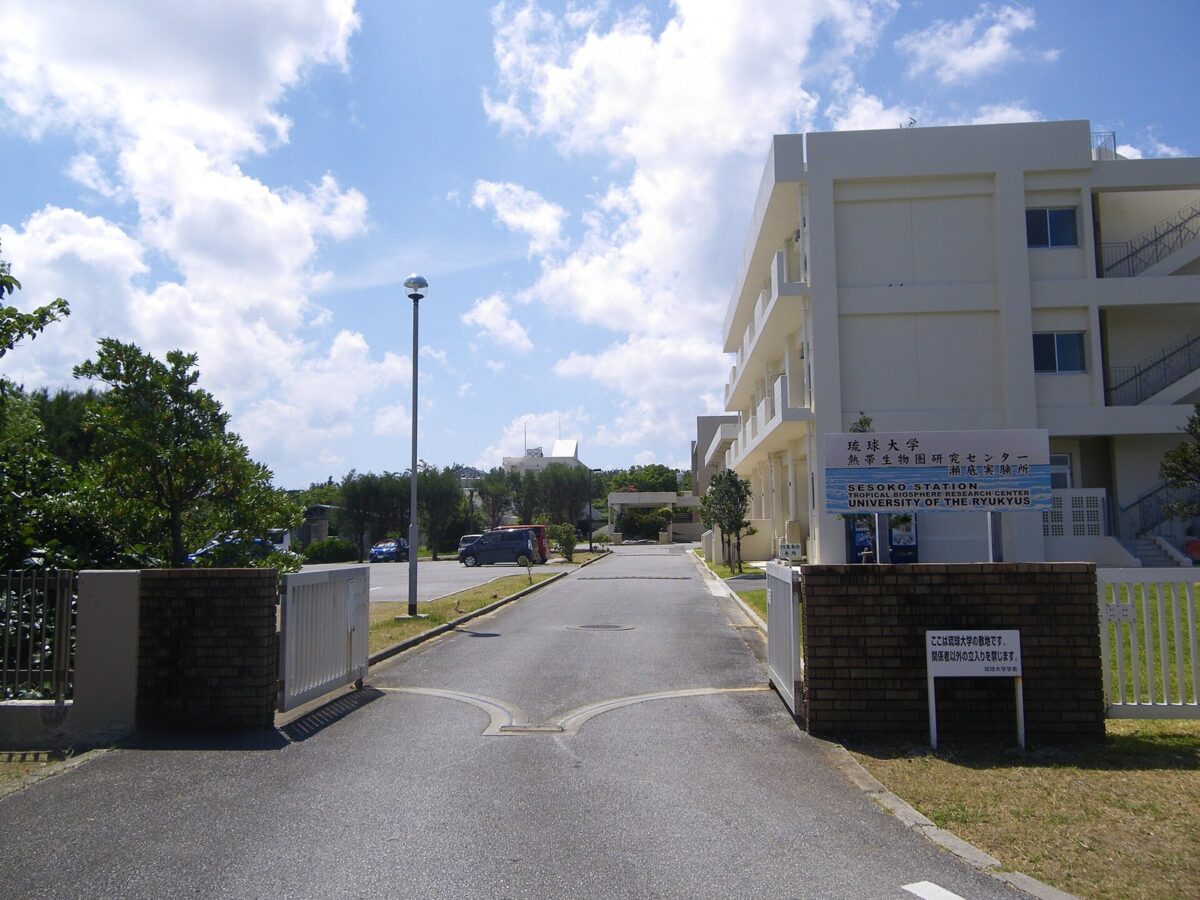門の向こうに白い3階建ての研究棟があり、「琉球大学 熱帯生物圏研究センター」の看板が立っている
