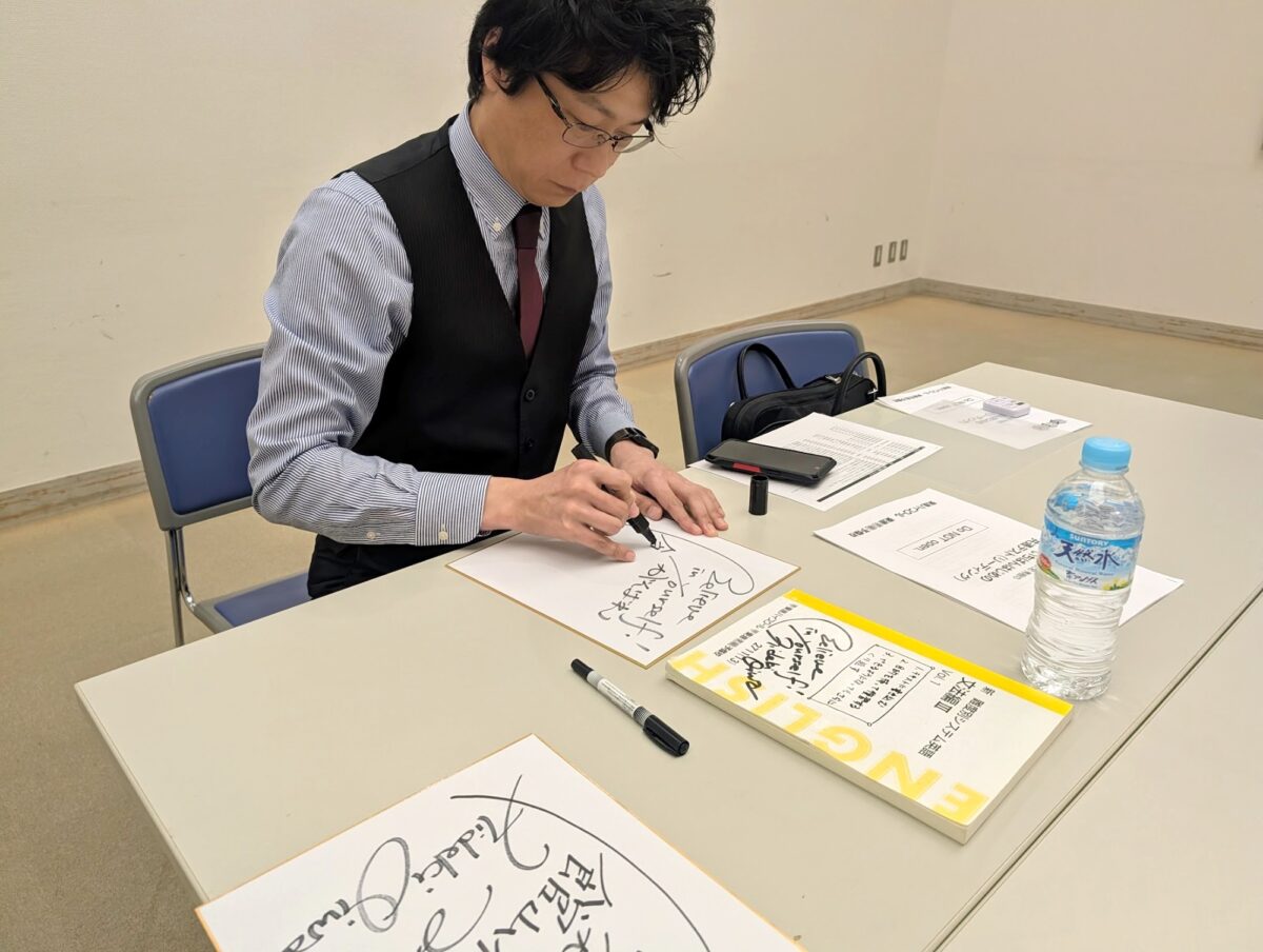 色紙に「Believe in yourself!」とサインを書く大岩先生