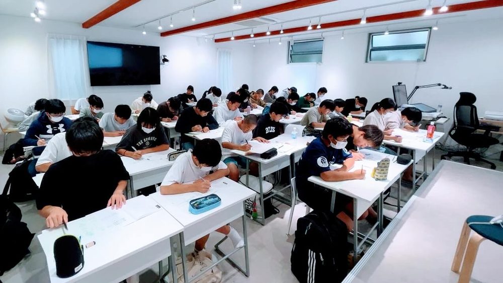 大教室で中学生30人ほどが机に向かい、テストを解いている授業の様子