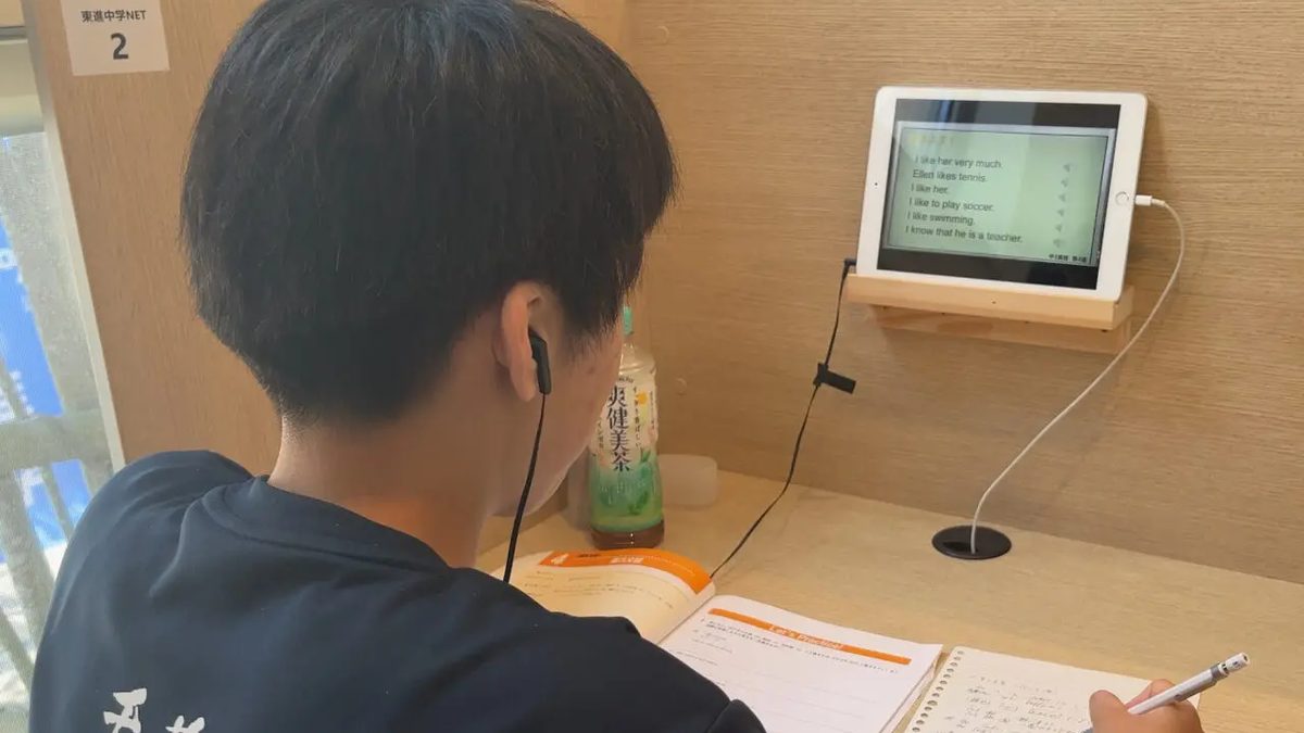 仕切りのある自習席で、イヤホンをつけてタブレットの東進の授業を受講する中学生