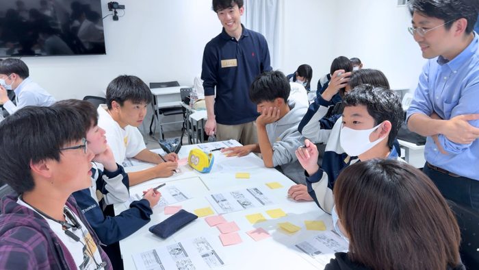 付せんを貼った資料を囲んで、中高生が話し合うプロジェクトの授業の様子