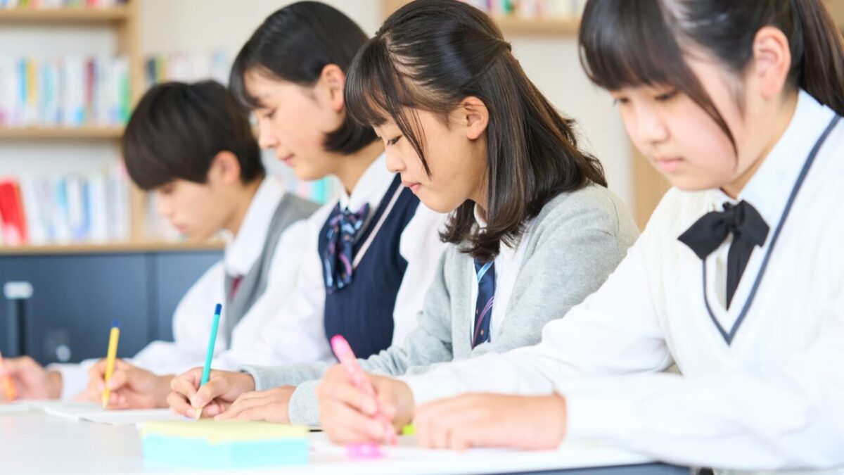 机を並べてテスト勉強に取り組む制服姿の中学生たち