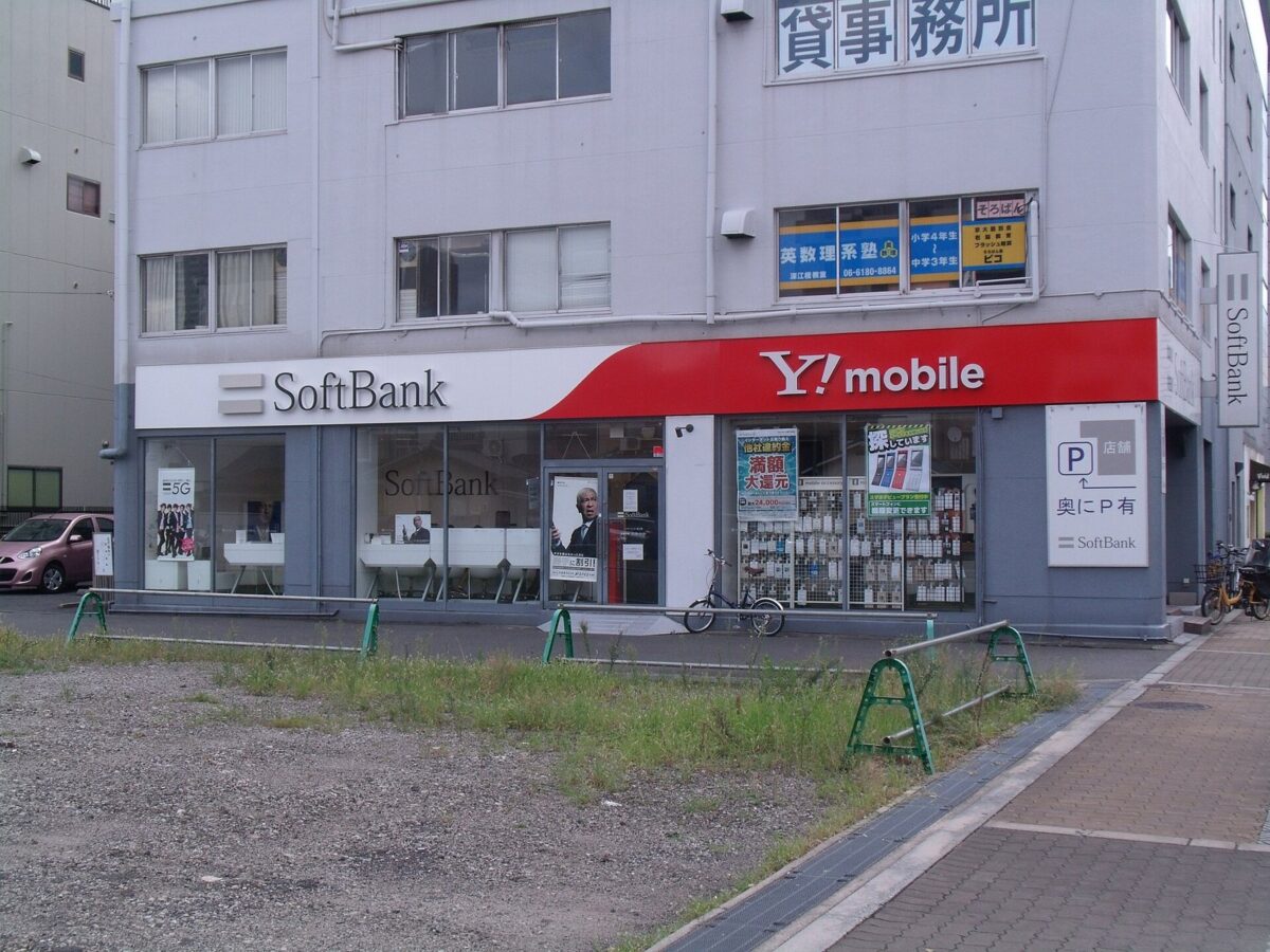 街の角にある、白い「SoftBank」と赤い「Y!mobile」の看板が並んだお店