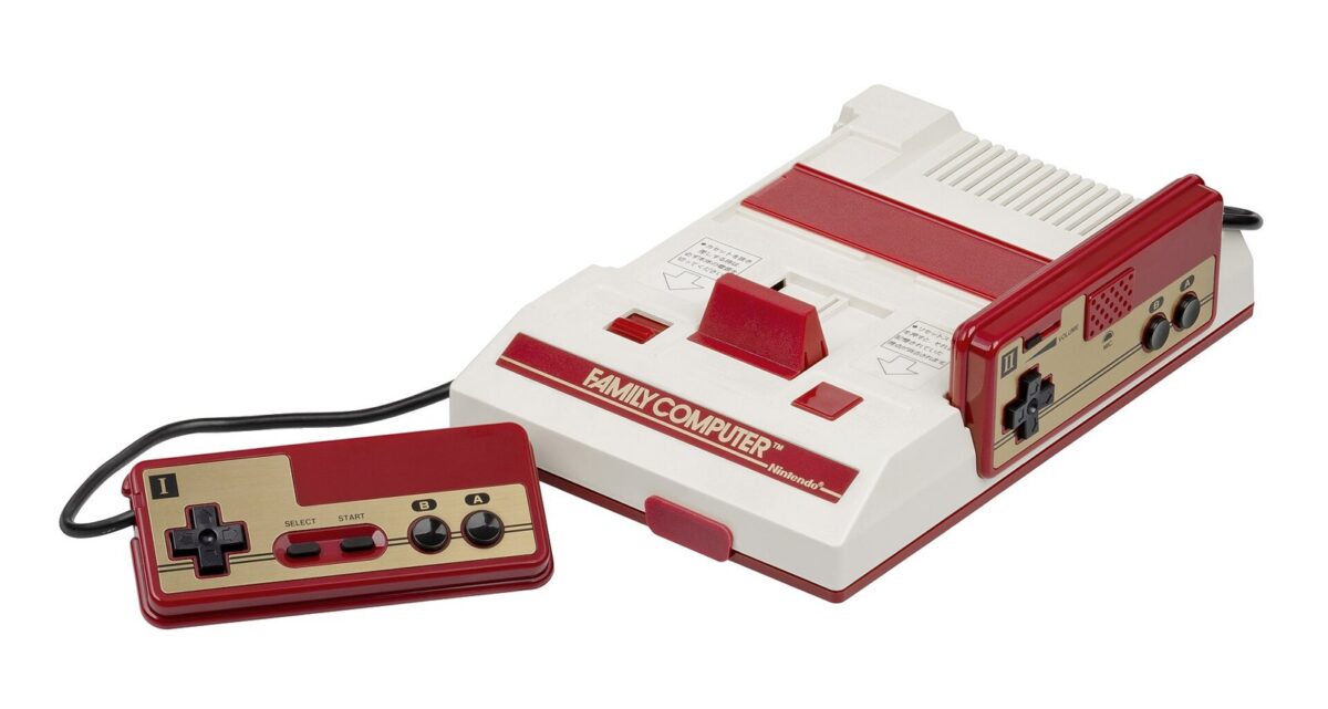 白とえんじ色の四角いゲーム機と、ケーブルでつながったえんじ色と金色のコントローラー