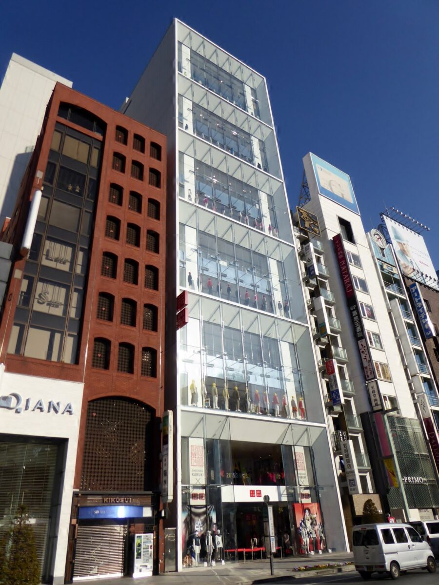 青空の下、銀座の通りに面して立つ、全面ガラス張りの細長いビル。どの階にもマネキンが並び、入り口に赤いユニクロの看板がある